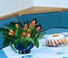 Gedeckter Tisch mit Tulpen und Gugelhupf